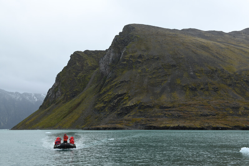 Ein Schlauchboot kommt zurück zum Kreuzfahrtschiff nach einem Landgang in Spitzbergen